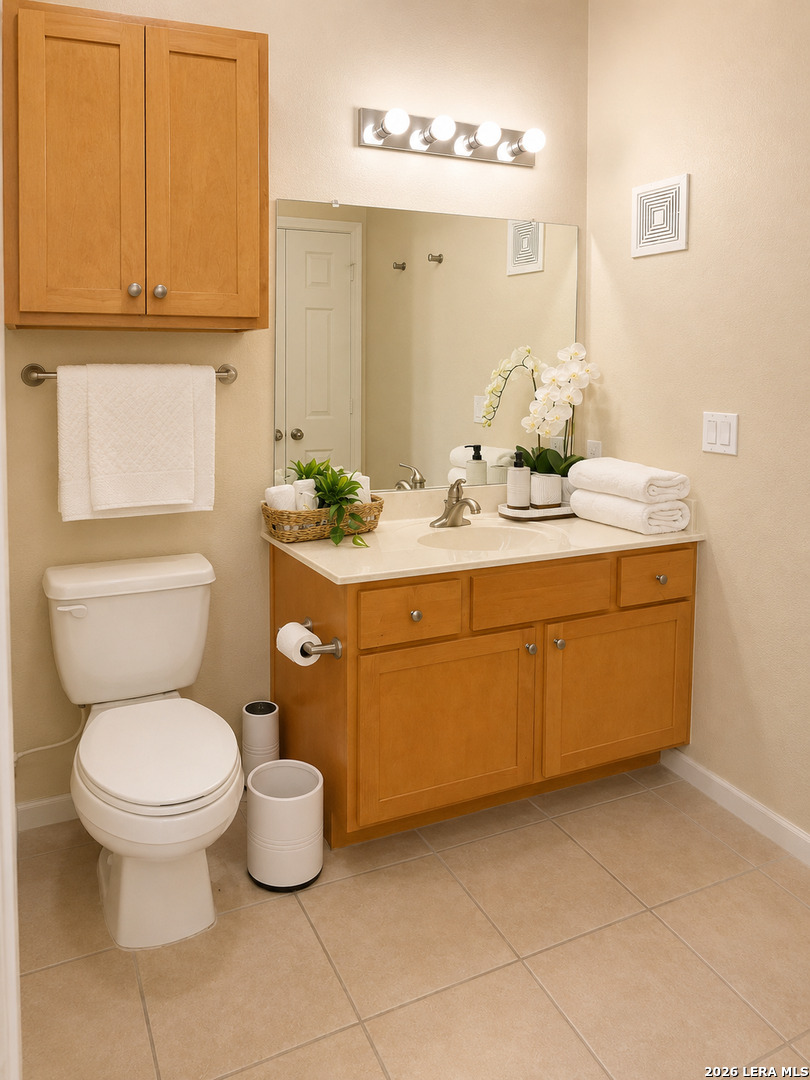 6160 Eckhert Road, Unit 804 San Antonio, TX 78240 - Photo 28 of 38 a bathroom with a toilet sink and mirror