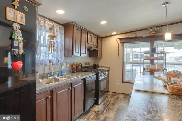 a kitchen with granite countertop a sink stove and cabinets