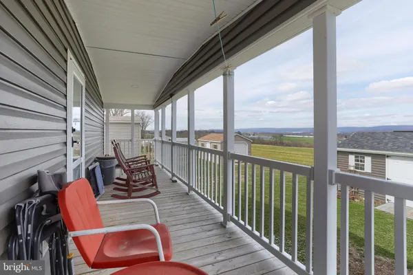 a balcony with chairs and wooden floor