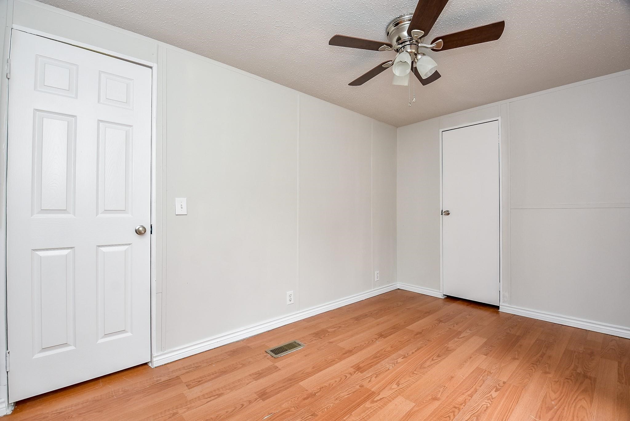 12842 Roy Harris Loop Conroe, TX 77306 - Photo 34 of 36 an empty room with wooden floor and fan