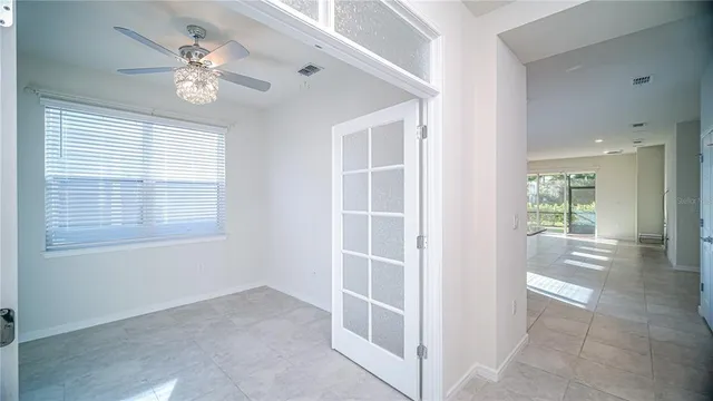 an empty room with a window and a fan
