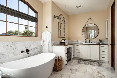 a bathroom with a tub sink and mirror