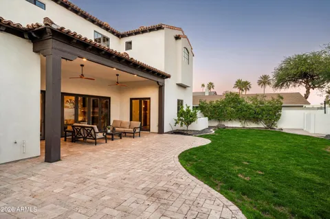 a view of a house with patio and a yard