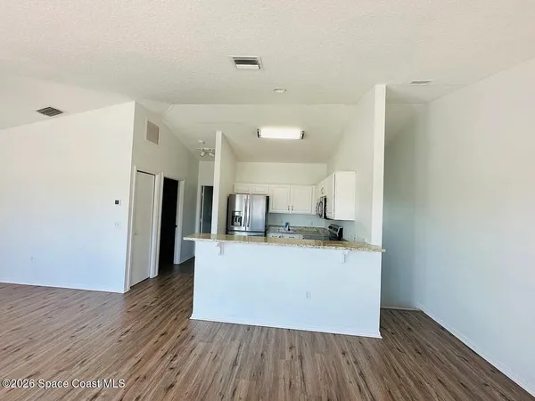 a kitchen with a sink and wooden floor