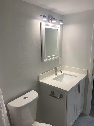 a bathroom with a toilet sink and mirror