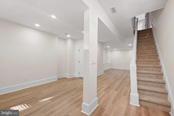 a view of a hallway with wooden floor and staircase