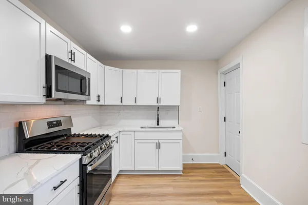 a kitchen with a sink cabinets and wooden floor