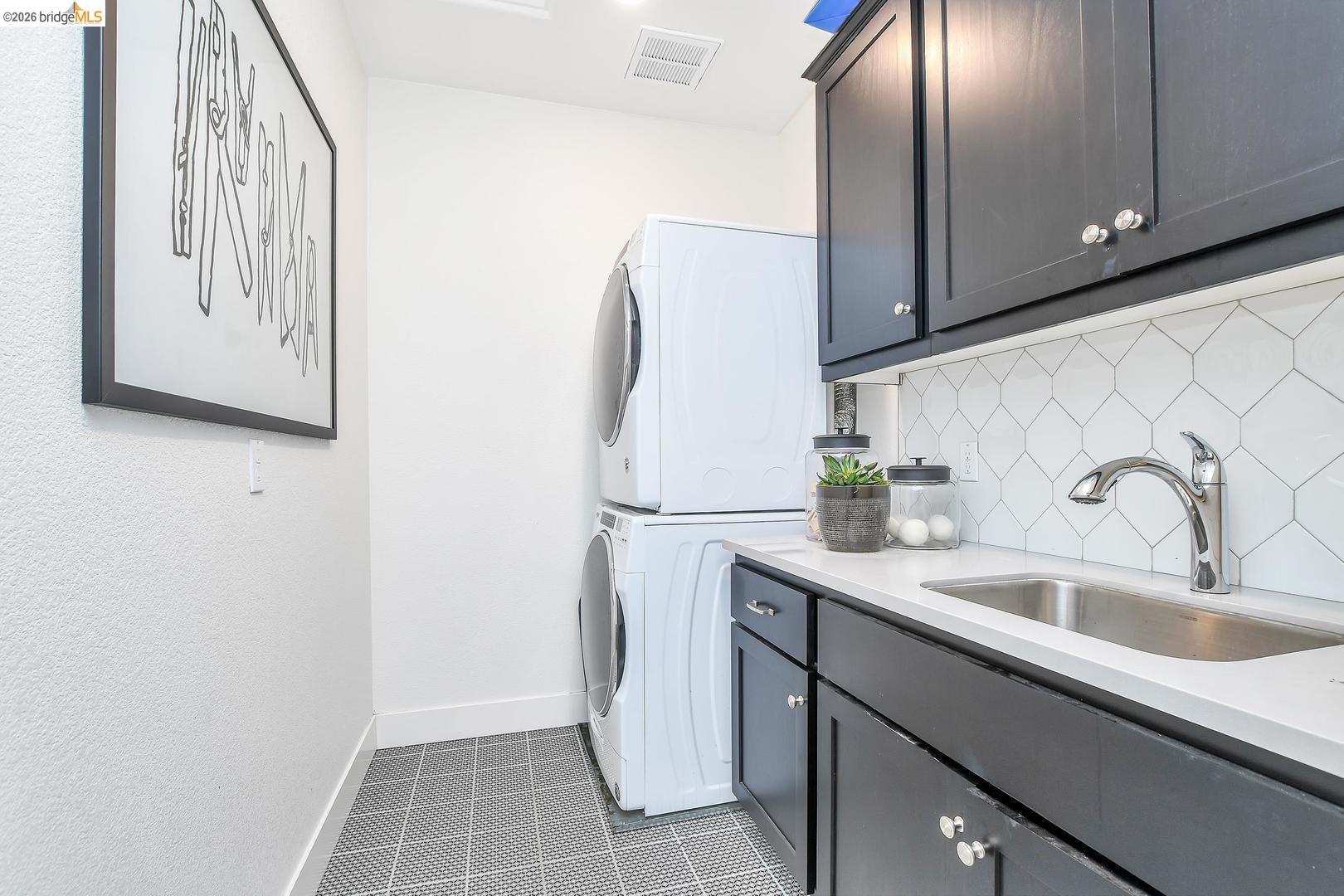 829 Hardcastle Ranch Road Oakley, CA 94561 - Photo 22 of 42 Compact laundry area with dark cabinetry, integrated stainless steel sink, and white geometric tile backsplash