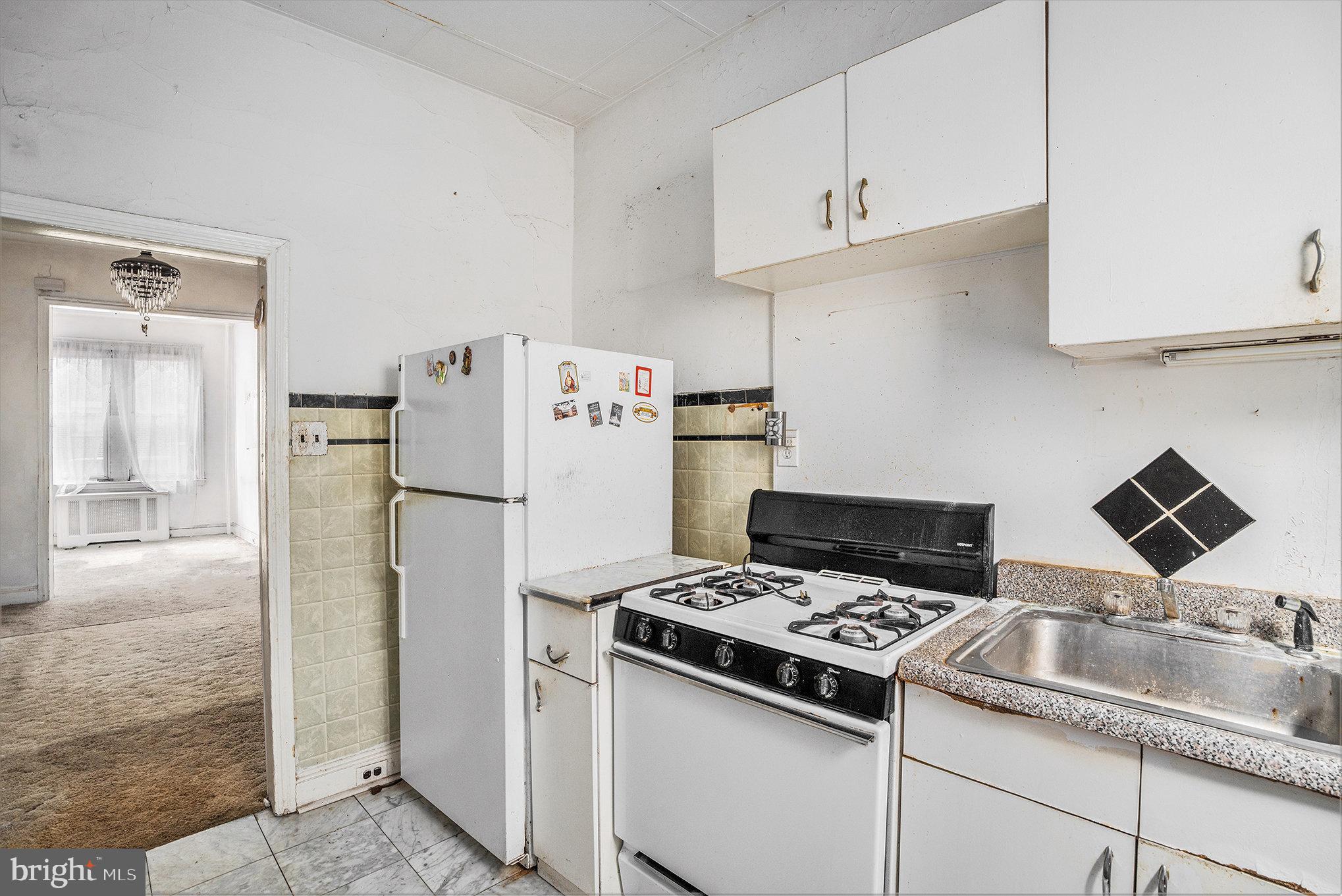 527 Christian Street Philadelphia, PA 19147 - Photo 5 of 28 a kitchen with refrigerator a stove a sink and cabinets