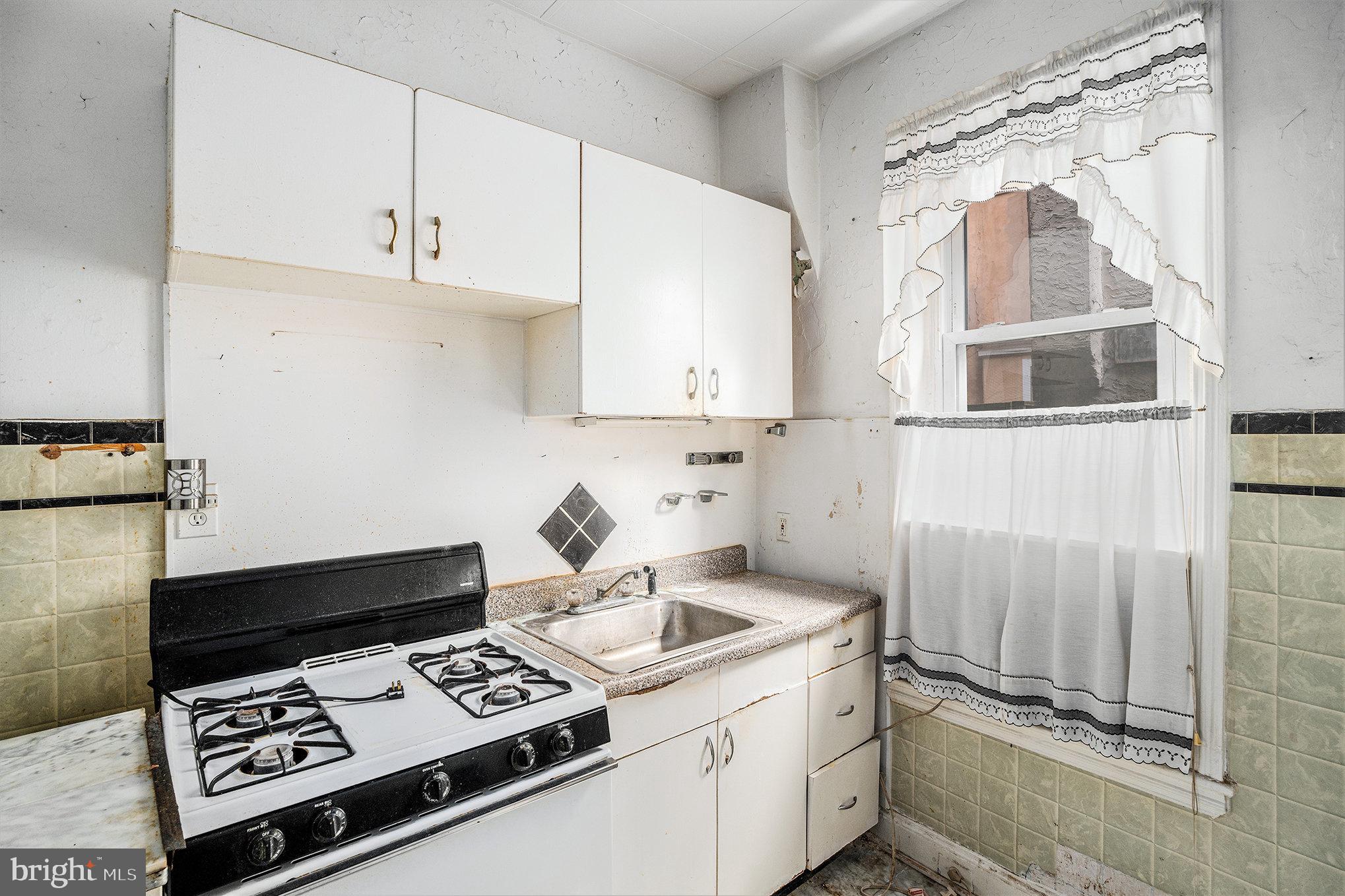 527 Christian Street Philadelphia, PA 19147 - Photo 6 of 28 a kitchen with kitchen island a stove a sink and a white cabinets