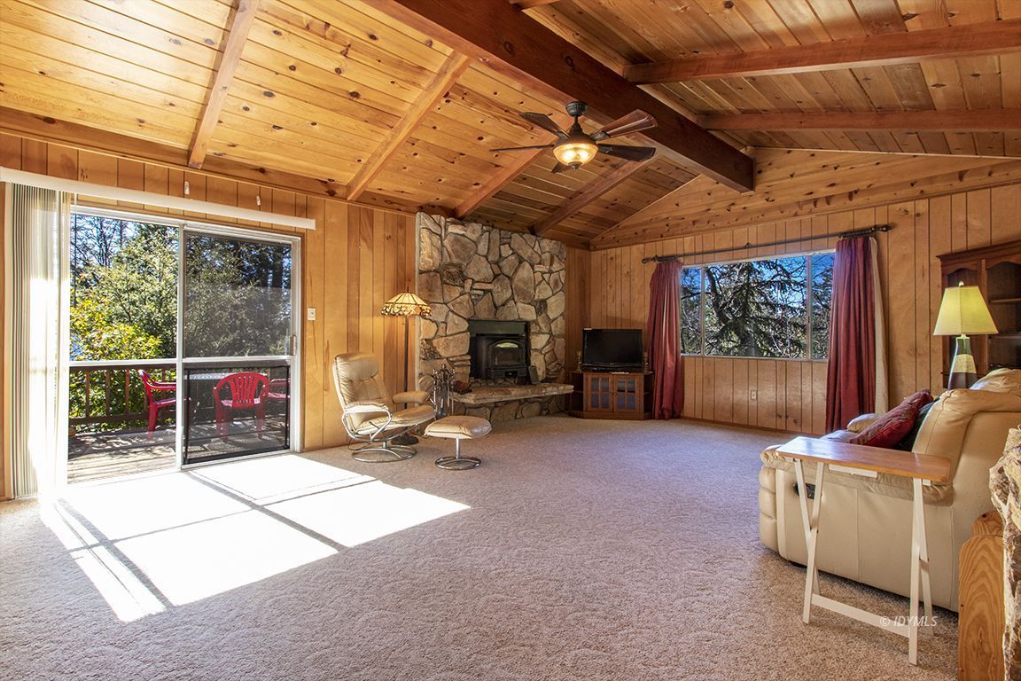 25230 Glen Road Idyllwild, CA 92549 - Photo 3 of 57 a living room with furniture a flat screen tv and a floor to ceiling window