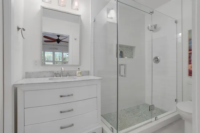 a bathroom with a shower sink vanity and mirror