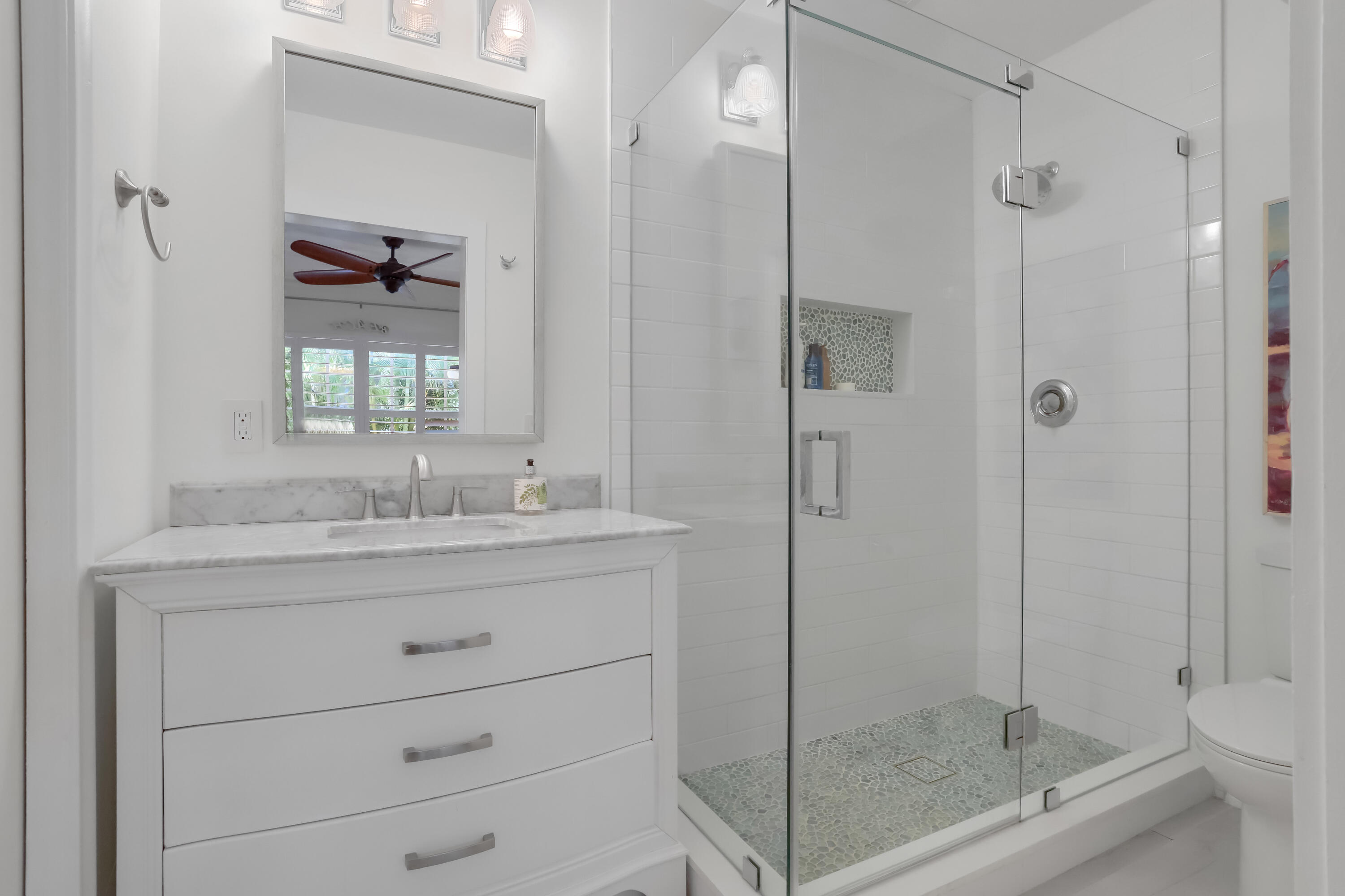 217 Gleason Street, Unit A Delray Beach, FL 33483 - Photo 12 of 28 a bathroom with a shower sink vanity and mirror