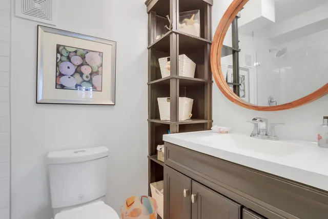 a bathroom with a toilet sink and mirror