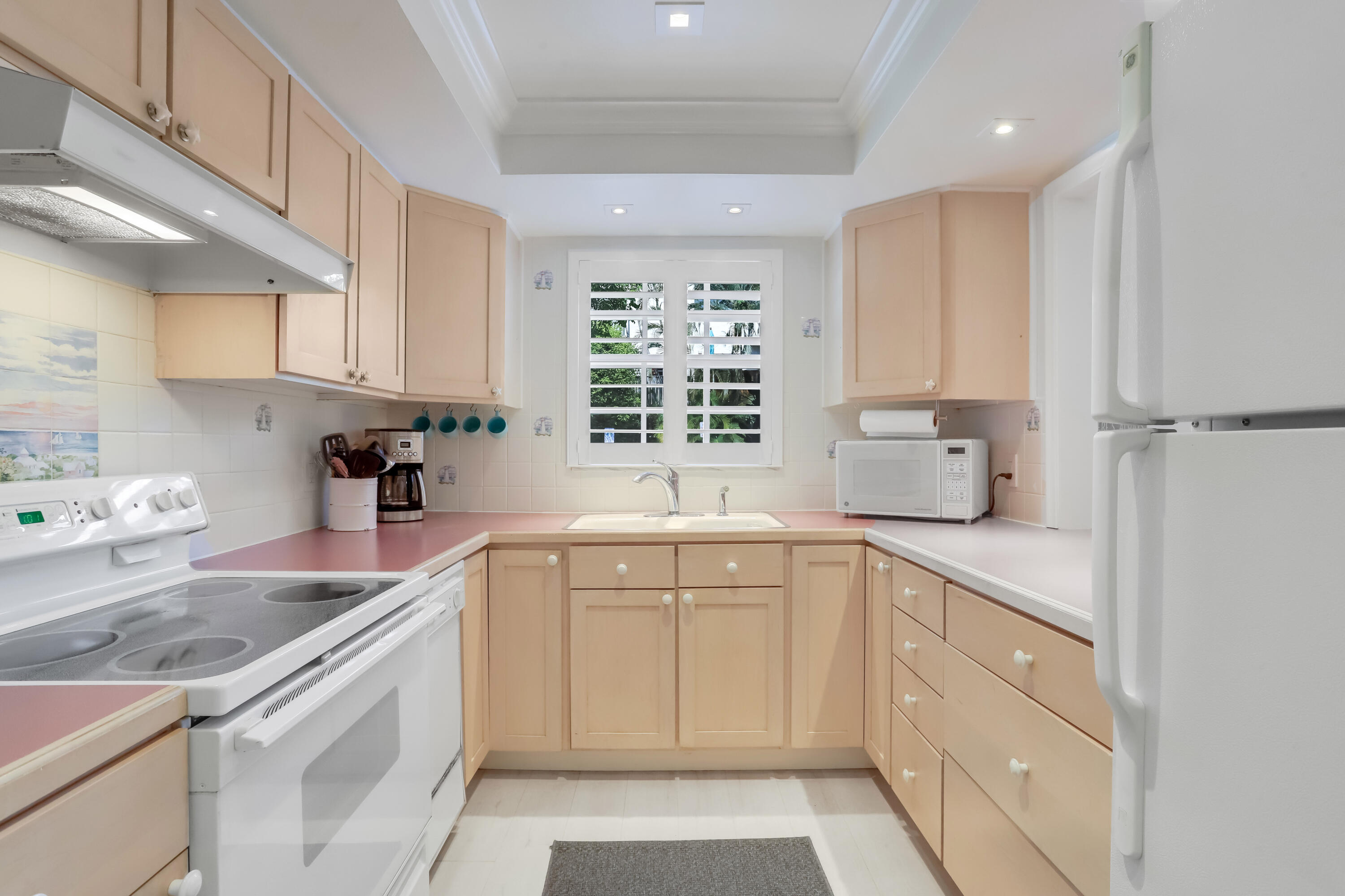 217 Gleason Street, Unit A Delray Beach, FL 33483 - Photo 9 of 28 a kitchen with a sink dishwasher stove and white cabinets