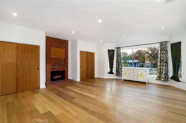 a view of an empty room with a fireplace and a window