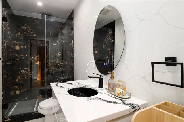 a bathroom with a sink a toilet and shower