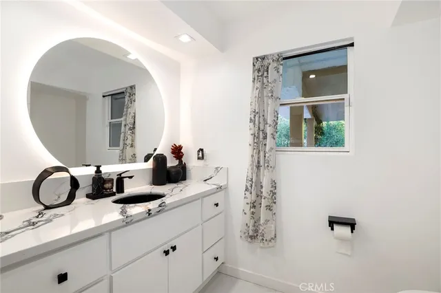 a bathroom with a granite countertop sink and a mirror
