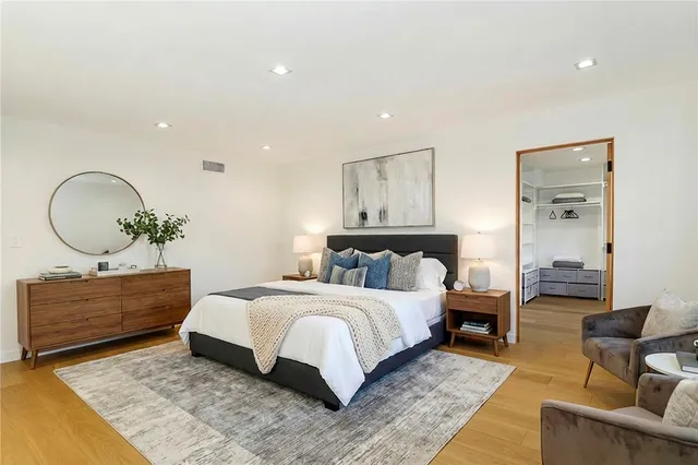 a spacious bedroom with a bed a couch and a dresser