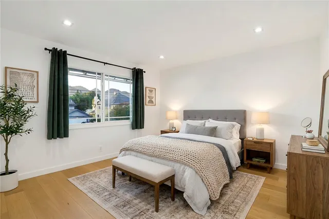 a spacious bedroom with a bed and a large window