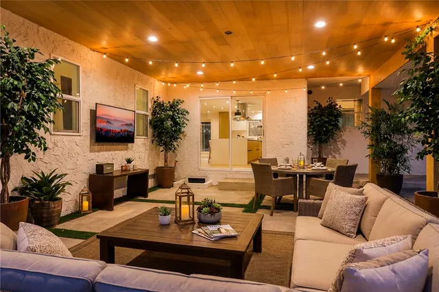 a living room with furniture kitchen view and a large window