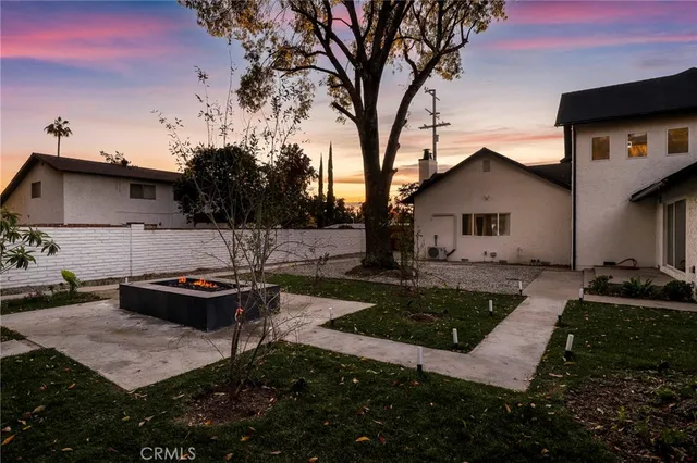 a view of a backyard with table and chairs and a fire pit