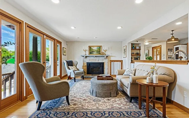 a living room with furniture a large window and a fireplace