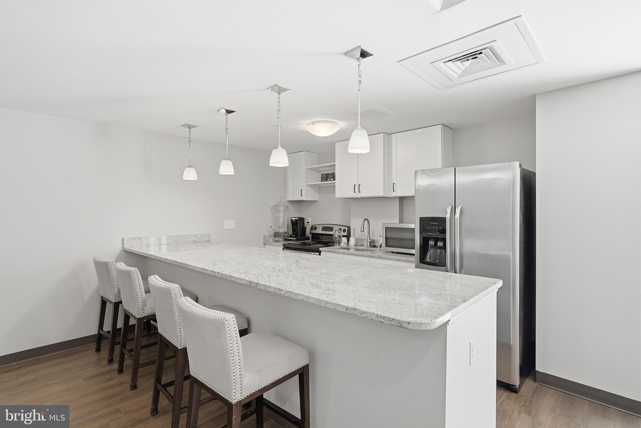 6301 Edsall Road, Unit 519 Alexandria, VA 22312 - Photo 24 of 33 a kitchen with stainless steel appliances granite countertop a sink a stove a refrigerator and chairs