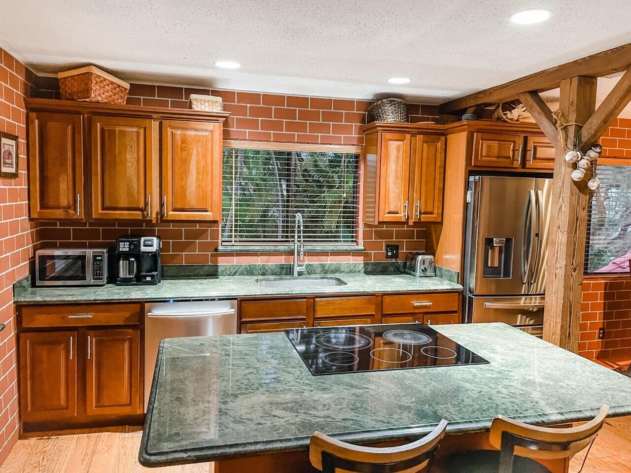 a kitchen with stainless steel appliances granite countertop a sink and a counter space