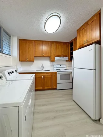 a kitchen with a refrigerator a stove a sink dishwasher and wooden cabinets with wooden floor