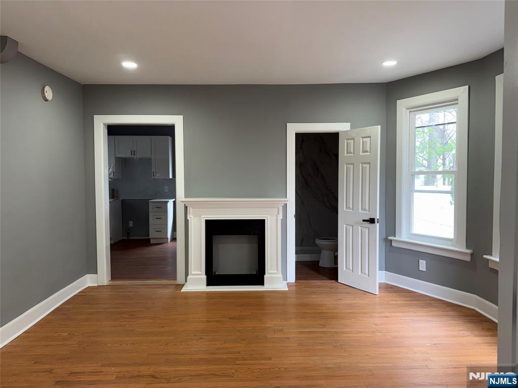178 Berry Street Hackensack, NJ 07601 - Photo 5 of 22 an empty room with wooden floor fireplace and windows
