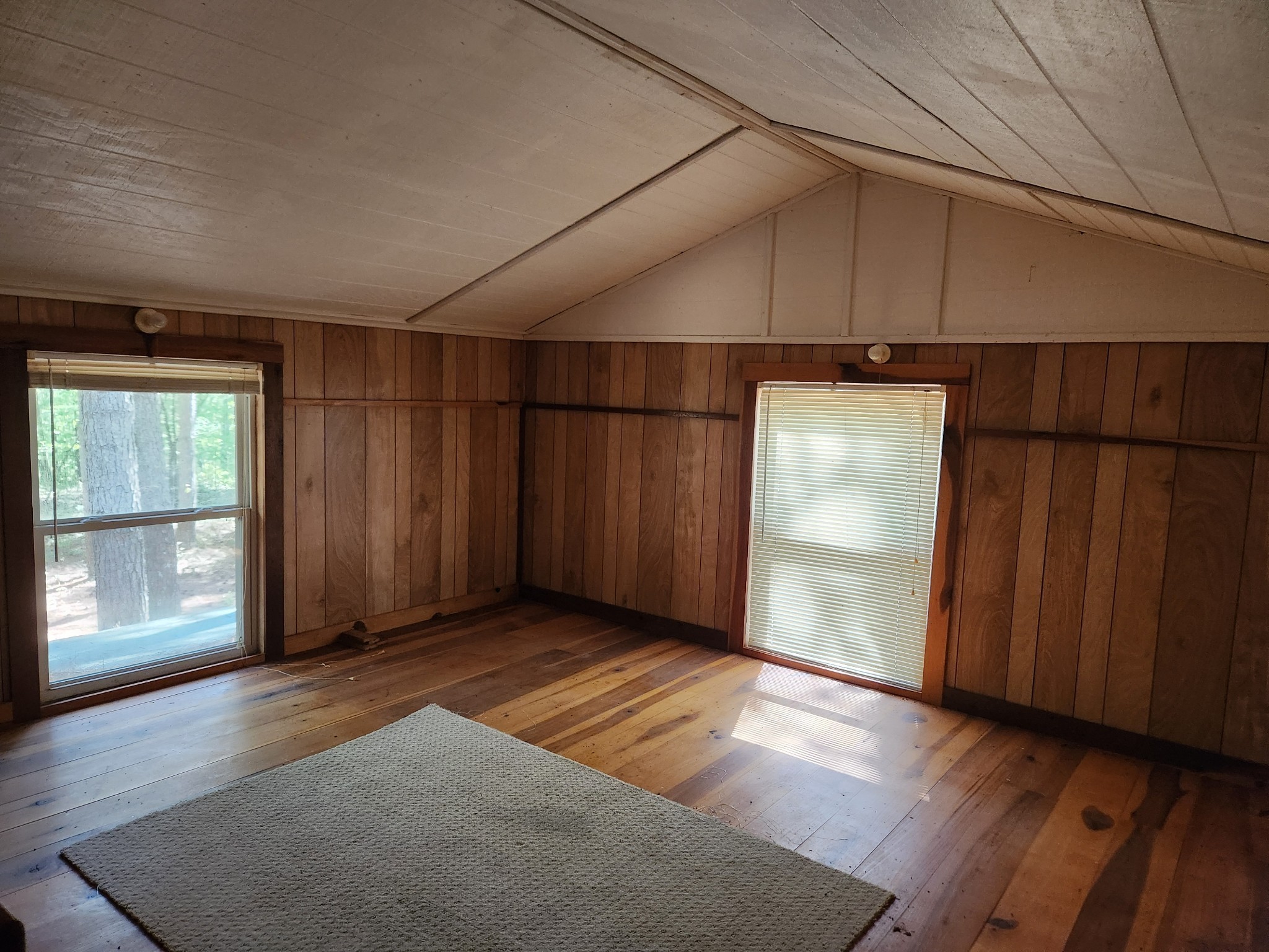 138 Vaughn Road Charlotte, TN 37036 - Photo 10 of 22 an empty room with wooden floor and windows