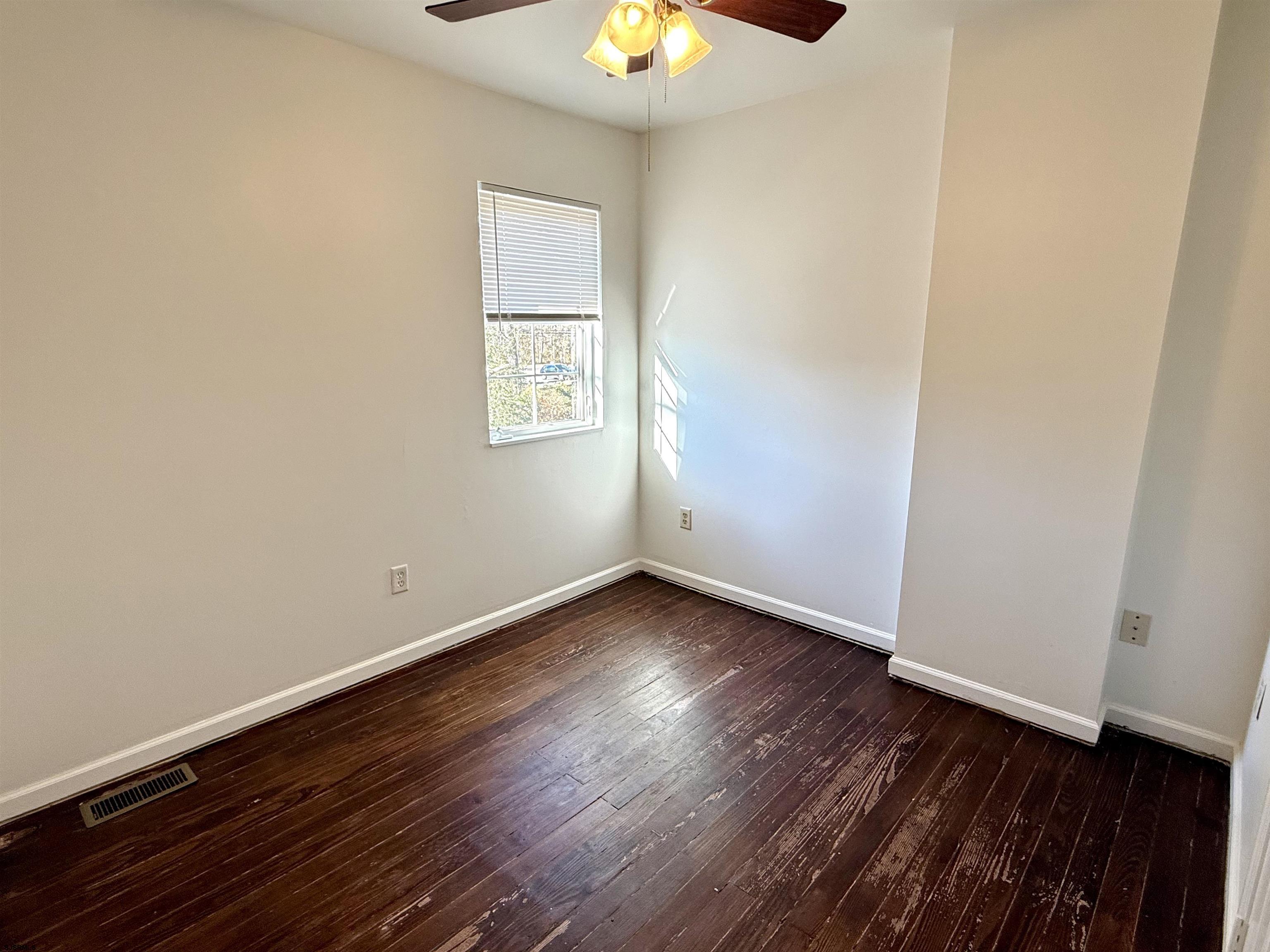 1309 Matthews Avenue, Unit B Mays Landing, NJ 08330 - Photo 11 of 19 an empty room with wooden floor and windows