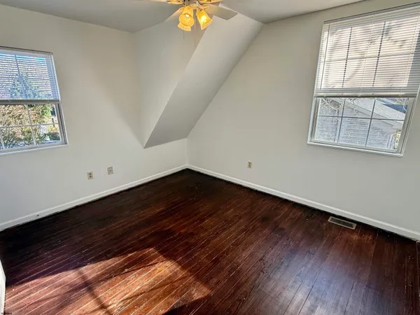 a view of room with wooden floor and fan