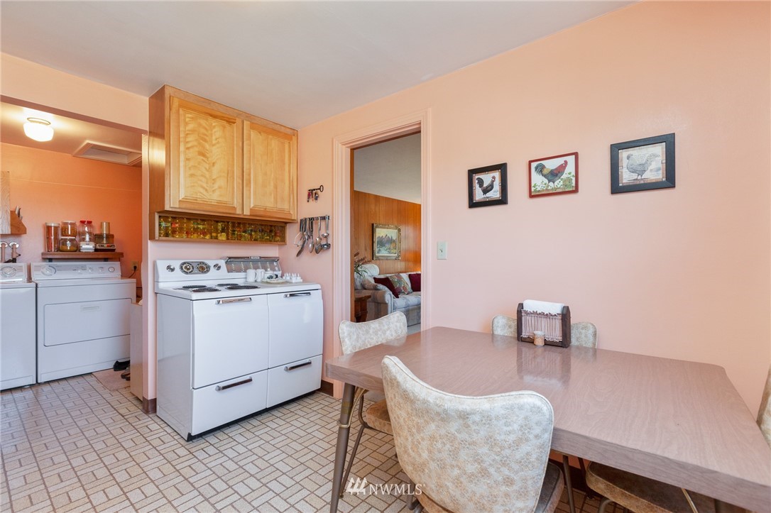 464 Bronson Way Northeast Renton, WA 98056 - Photo 7 of 25 a kitchen with a dining table chairs and white cabinets