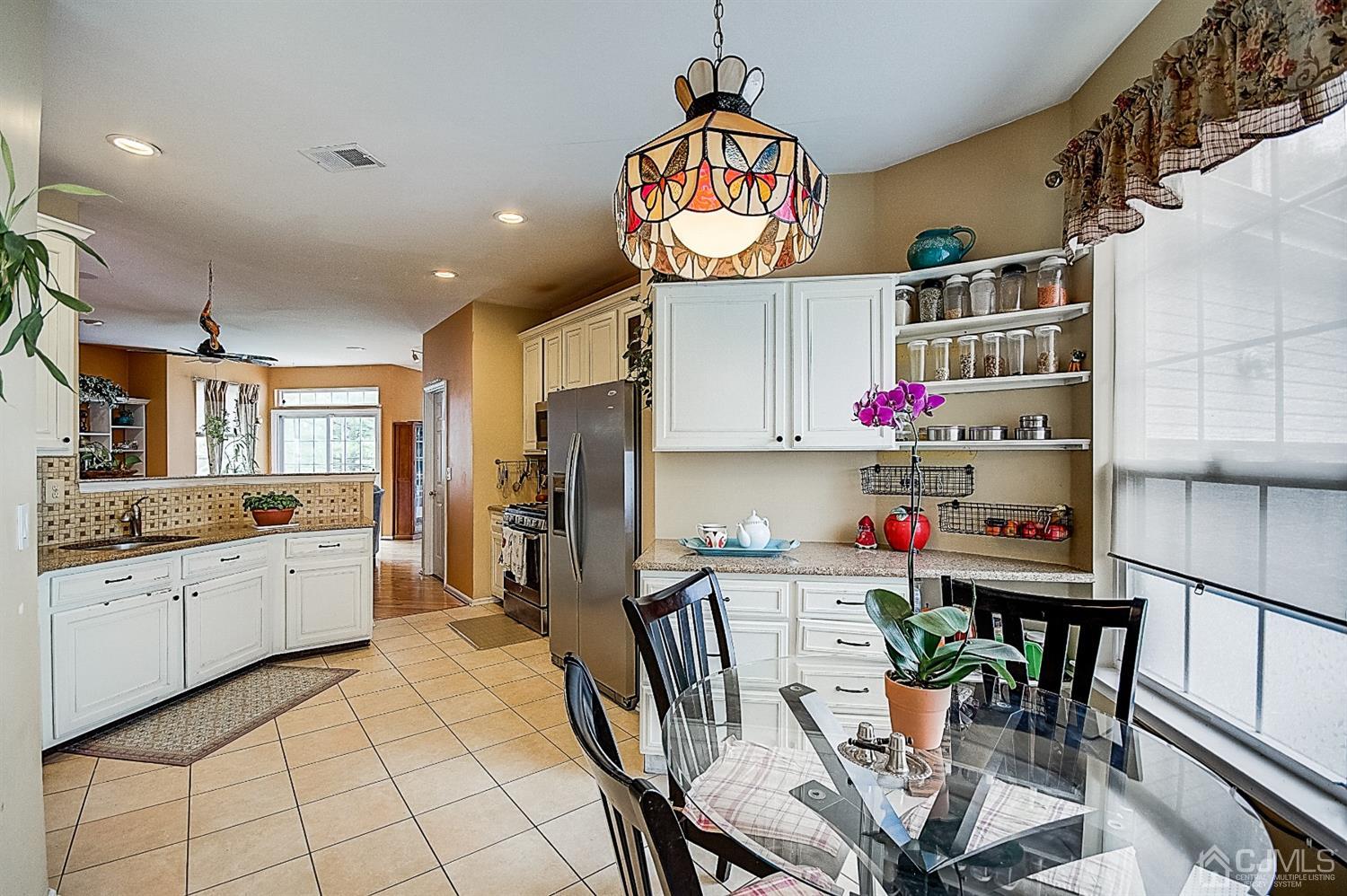 51 Timber Ridge Road North Brunswick, NJ 08902 - Photo 19 of 57 a kitchen with stainless steel appliances a dining table chairs and stove top oven