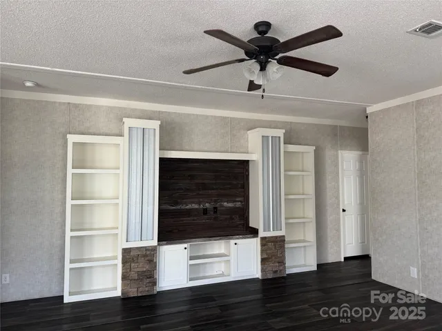 a living room with wooden floor and ceiling fan