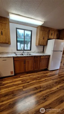 a view of a kitchen with wooden floor and a sink