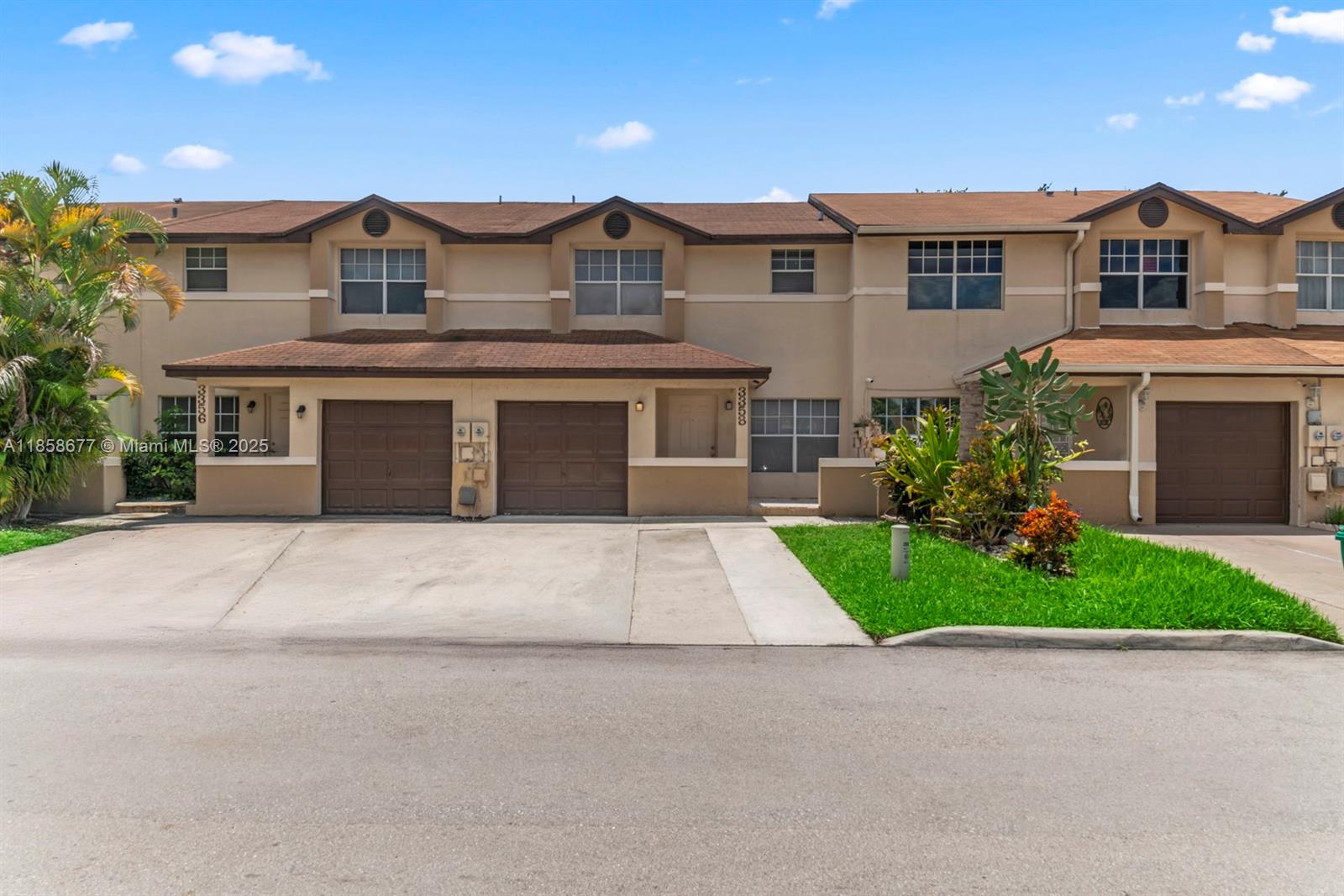 a front view of a house with a garden and garage