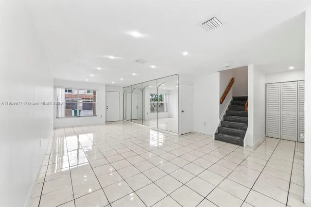 a view of an empty room with stairs and ventilation