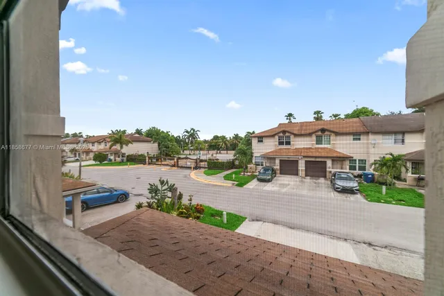 an empty room with wooden floor chandelier fan and windows
