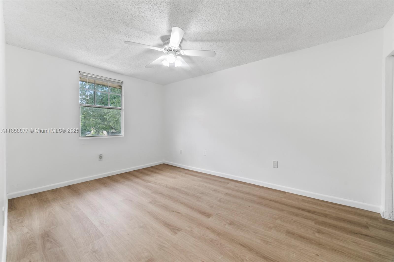 3358 Northwest 198th Terrace Miami Gardens, FL 33056 - Photo 20 of 26 an empty room with wooden floor chandelier fan and windows