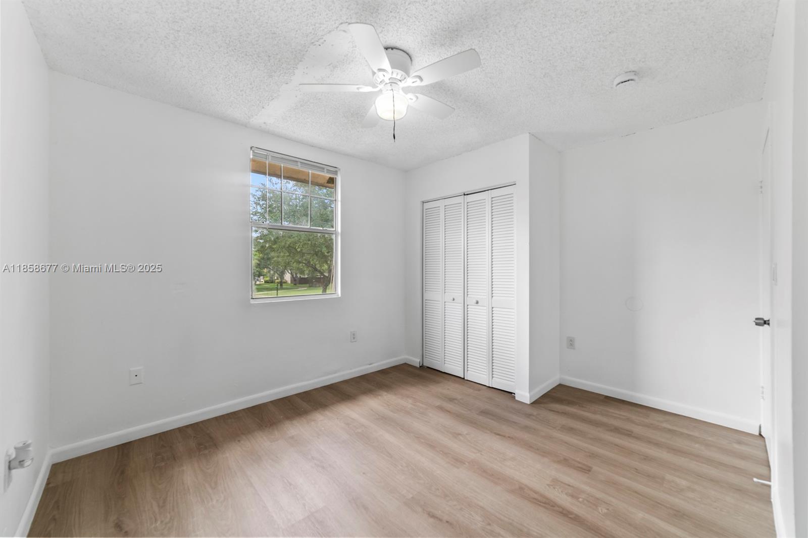3358 Northwest 198th Terrace Miami Gardens, FL 33056 - Photo 24 of 26 an empty room with wooden floor chandelier fan and windows