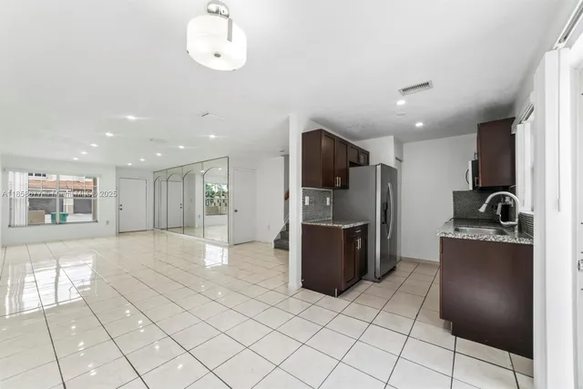 a kitchen with stainless steel appliances granite countertop a refrigerator and a sink