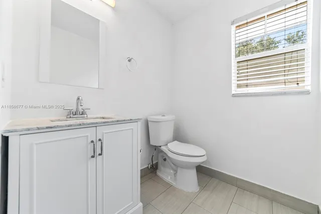 a bathroom with a sink toilet and a mirror