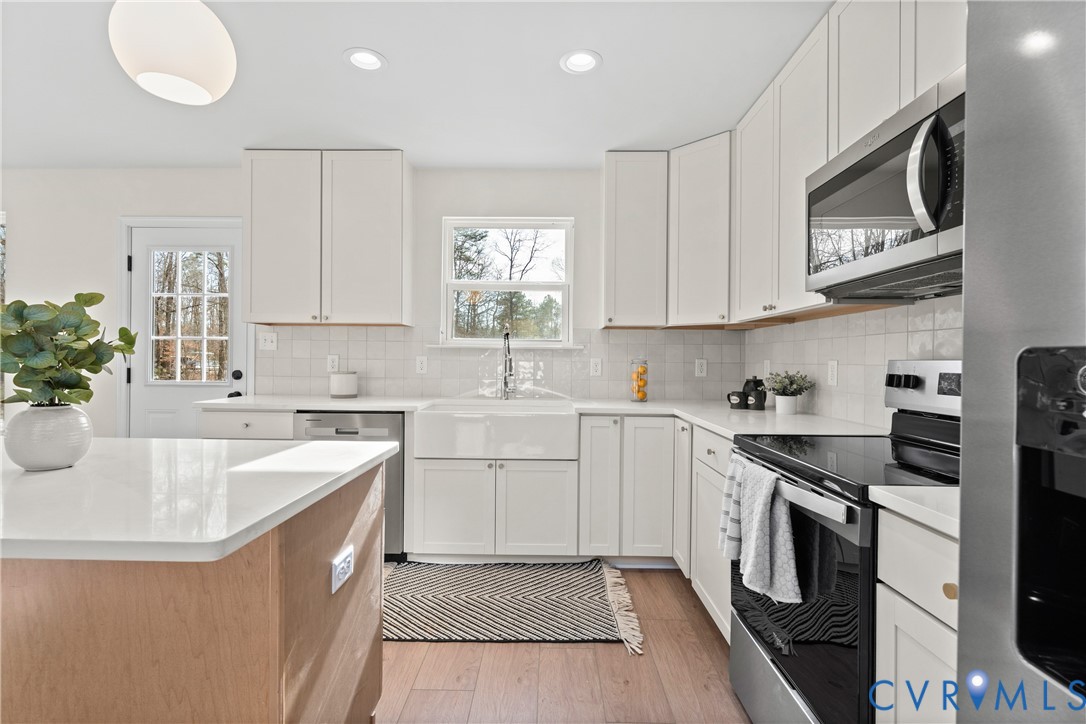 887 Campers Lane Ruther Glen, VA 22546 - Photo 11 of 42 a kitchen with stainless steel appliances granite countertop a sink stove and microwave