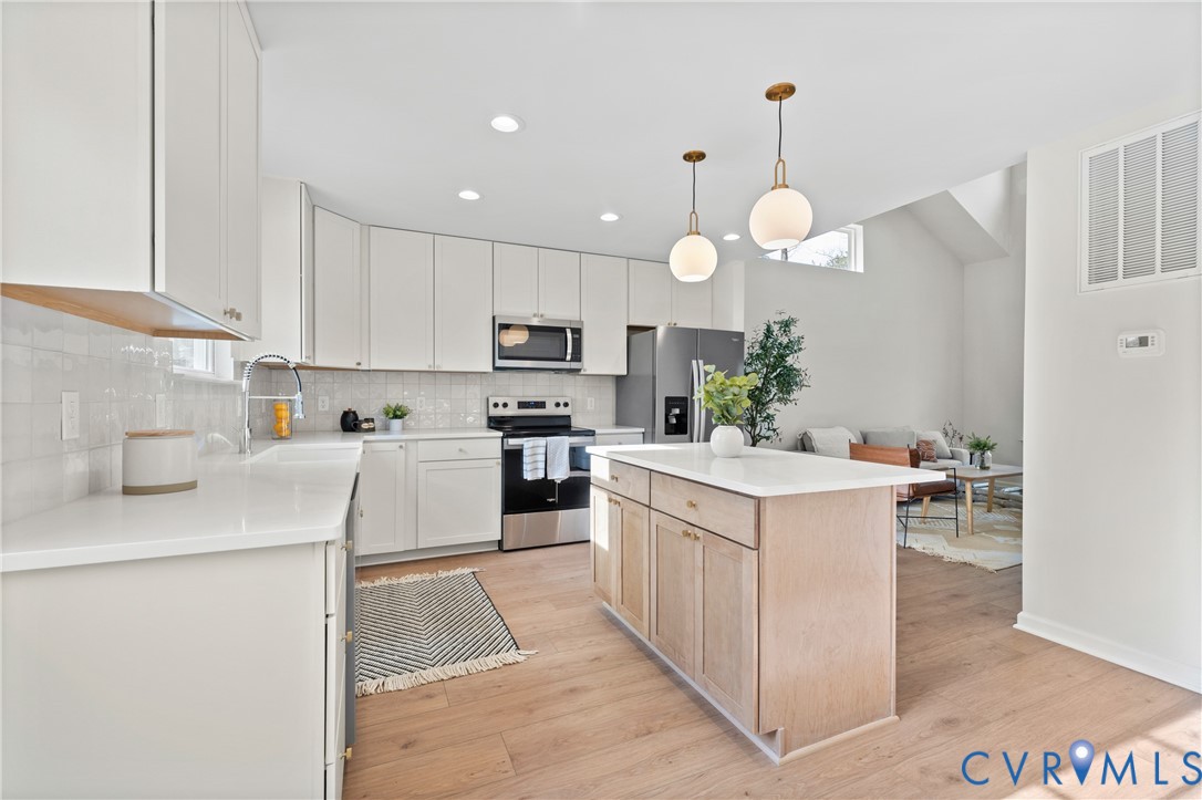 887 Campers Lane Ruther Glen, VA 22546 - Photo 12 of 42 a kitchen that has a lot of white cabinets and stainless steel appliances