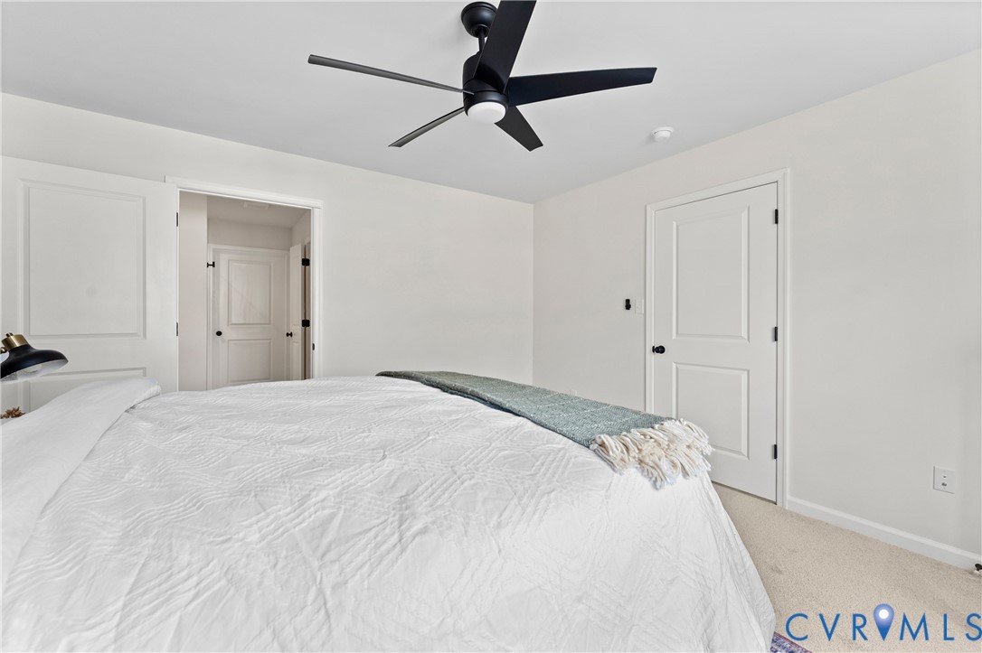 887 Campers Lane Ruther Glen, VA 22546 - Photo 18 of 42 a bedroom with a bed and a chandelier