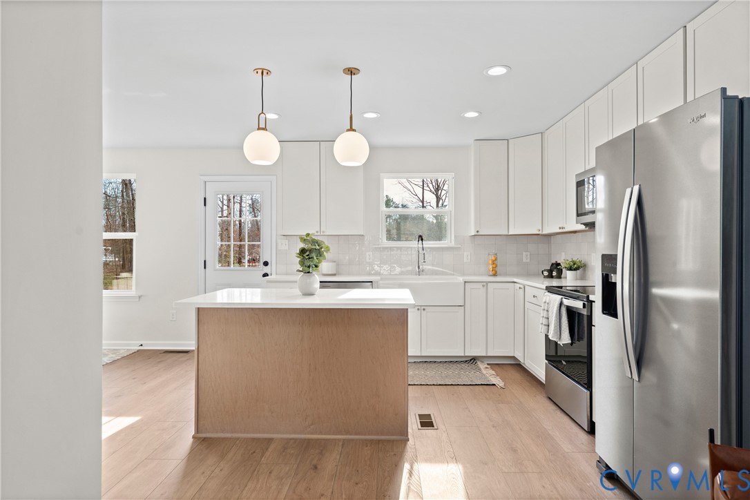 887 Campers Lane Ruther Glen, VA 22546 - Photo 6 of 42 a kitchen with a refrigerator a sink and dishwasher with wooden floor