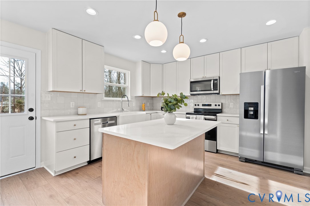 887 Campers Lane Ruther Glen, VA 22546 - Photo 7 of 42 a kitchen with white cabinets and white appliances